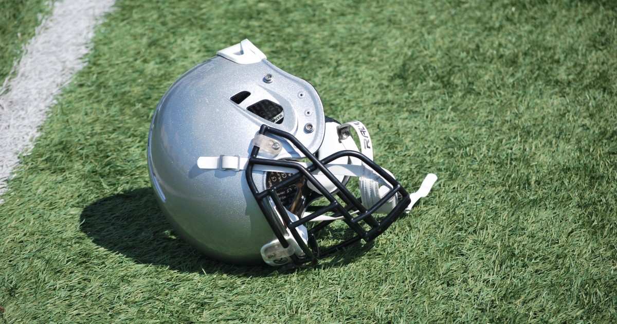 Football helmet laid carelessly in the grass