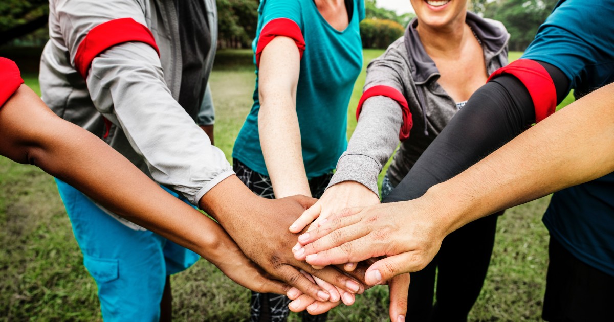 Lots of hands stacked in a circle showing a team mentality