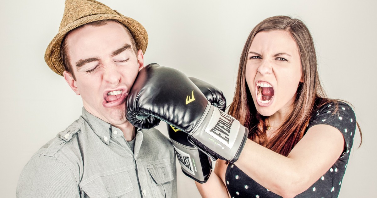 Funny picture of lady punching a guy with a boxing glove