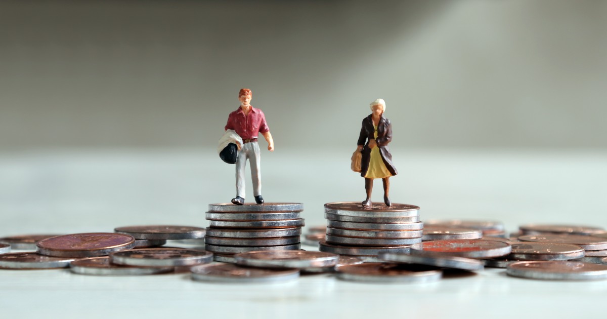 Miniature male and female figurines standing on equal piles of coins