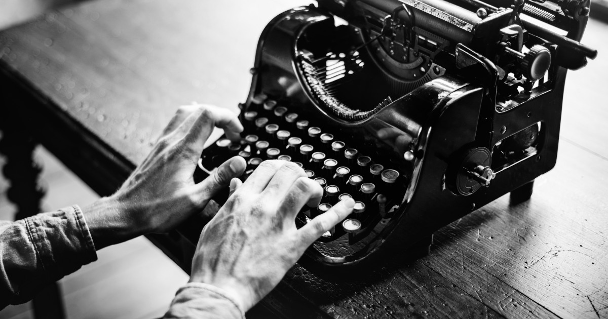 An old fashioned typewriter with hands typing