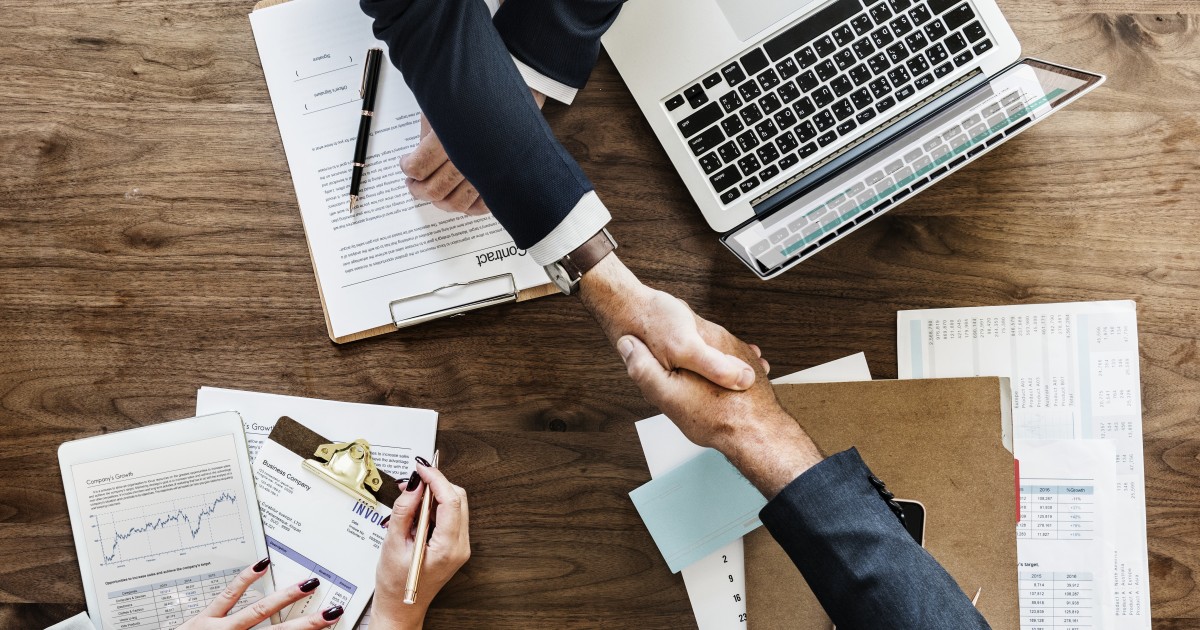 Two men shaking hands as the work together